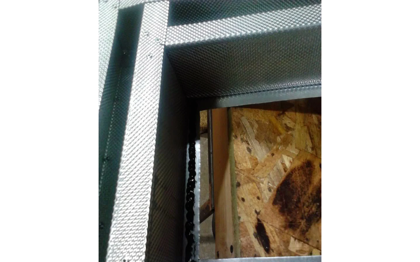 Нанесение высокотемпературного герметика на одну из четырёх сторон окна